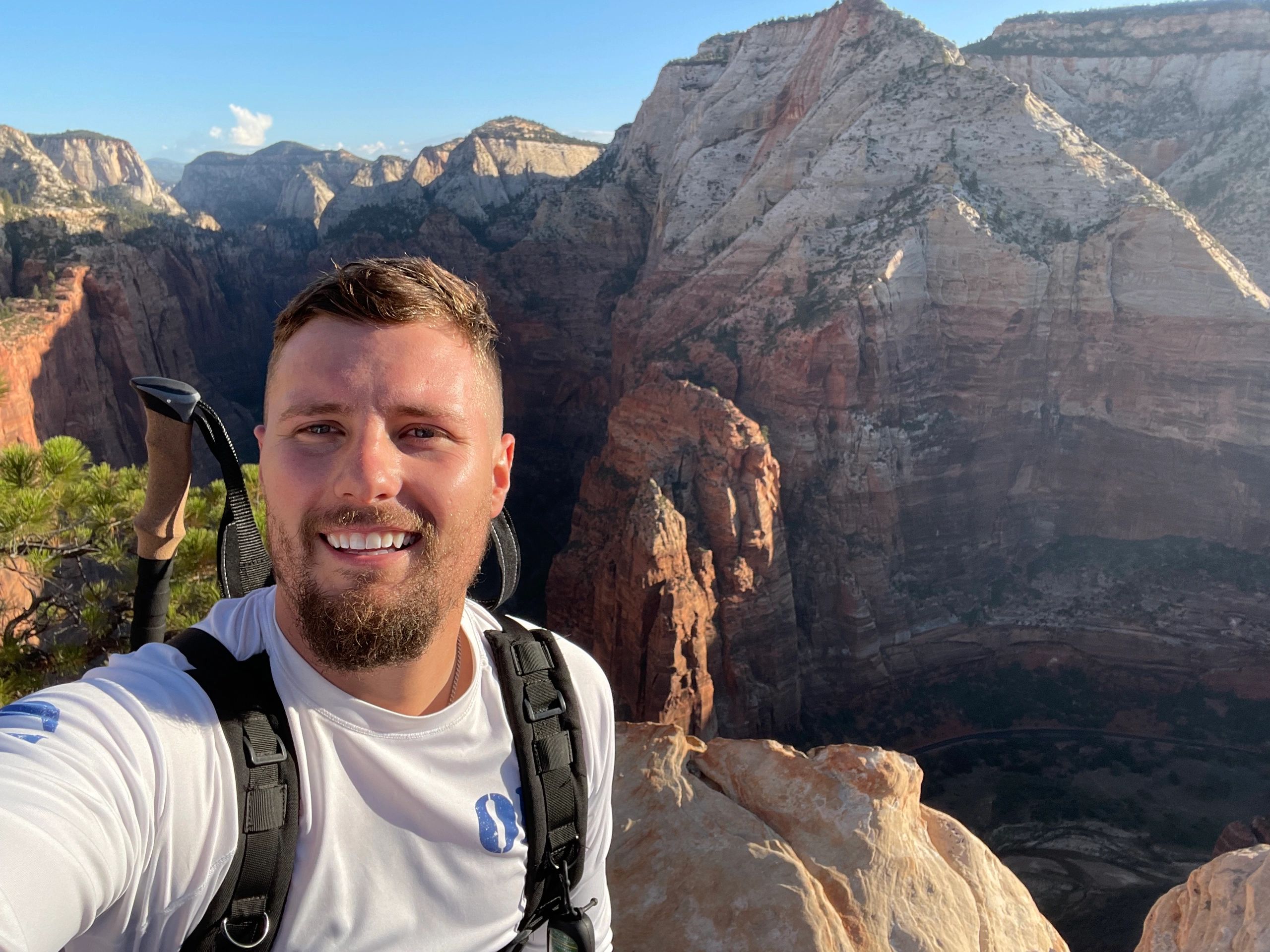 Man taking a selfie at a scenic mountain viewpoint.